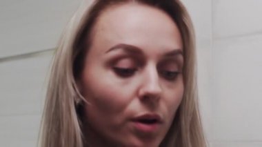 Kadın krem sürüyor ve kameraya bakıyor.