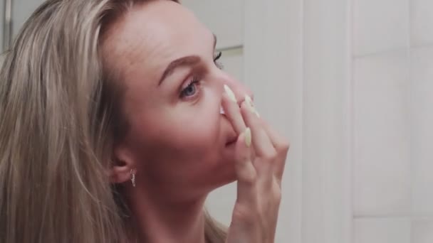 Mulher aplicando creme sob os olhos e olhando no espelho desfrutar de beleza natural e saudável — Vídeo de Stock