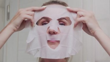 Yüzüne maske takan ve kameraya bakan bir kadın.