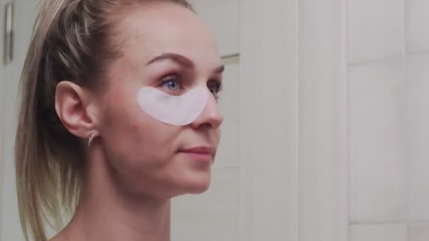 Close de mulher remove remendos na área sob os olhos. — Vídeo de Stock