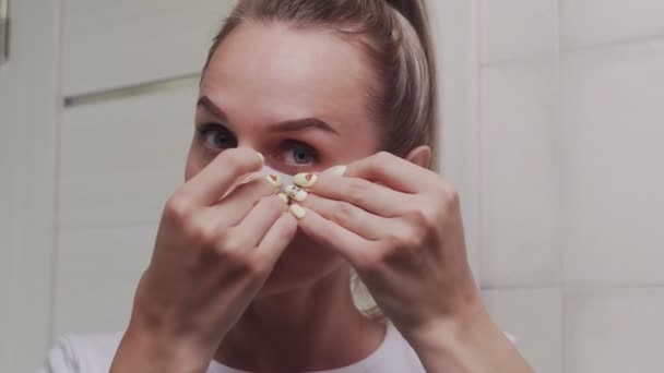 Nahaufnahme von Frau legt sich Kollagenpolster unter die Augen und blickt in die Kamera — Stockvideo