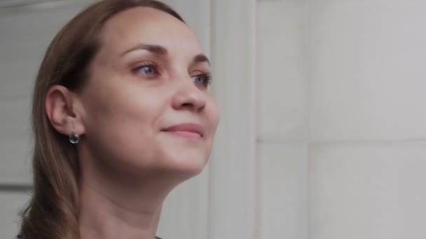 Banyoda aynanın önünde beyaz bir kadın var. Yüz yıkama, cilt bakımı, sağlık. — Stok video