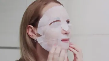 Yetişkin bir kadının yüzüne maske takıp kameraya baktığı fotoğrafı çek.