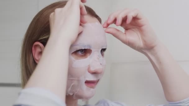 CLose up van volwassen vrouw verwijdert masker op haar gezicht kijken in spiegel — Stockvideo