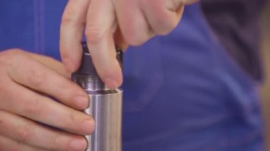 İşçi elleri fabrikada sondaj yapıyor.