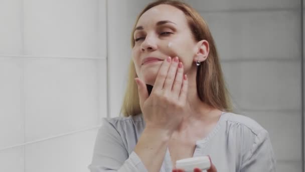 O femeie adultă care se uită în oglindă se bucură de frumusețe naturală și sănătoasă — Videoclip de stoc