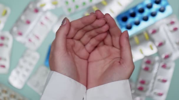 Női orvosok kéz fog tablettát sok hólyagok a háttérben — Stock videók