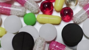 Beyaz arka plana düşen çok sayıda farklı türde hap.