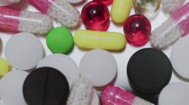 Beyaz arka plana düşen çok sayıda farklı türde hap.