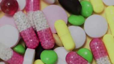 Beyaz arka plana düşen çok sayıda farklı türde hap.