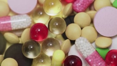 Beyaz arka plana düşen çok sayıda farklı türde hap.