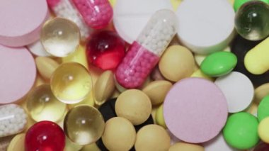 Beyaz arka plana düşen çok sayıda farklı türde hap.