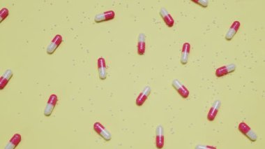 Sarı arka planda pembe ve beyaz haplar.