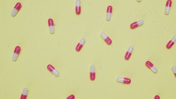 Pink and white pills on yellow background — Stock Video