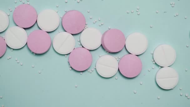 Pastillas rosadas y blancas sobre fondo azul — Vídeos de Stock