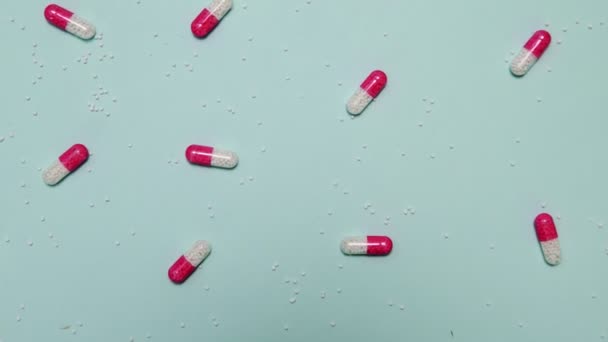 Dużo różowych i białych tabletek na niebieskim tle — Wideo stockowe