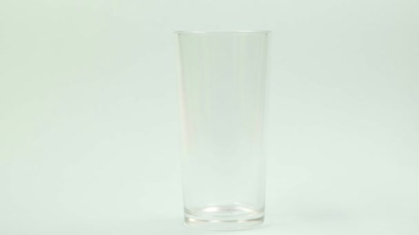 Un comprimé jaune effervescent contre la douleur tombe dans un verre et dissout Timelaps 