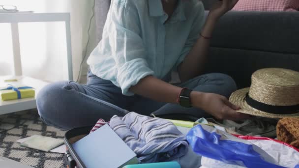 Girl neatly puts clothes for vacation in a suitcase and talking on smartphone — Stock Video