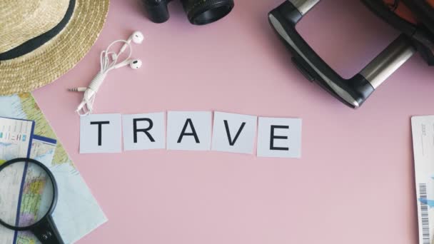 Top vue mains posées sur le bureau rose mot TRAVEL — Video