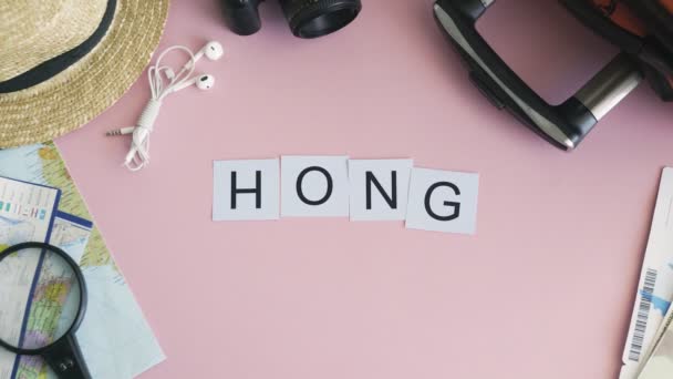 Manos de vista superior que ponen en la palabra de escritorio rosa HONG KONG — Vídeos de Stock