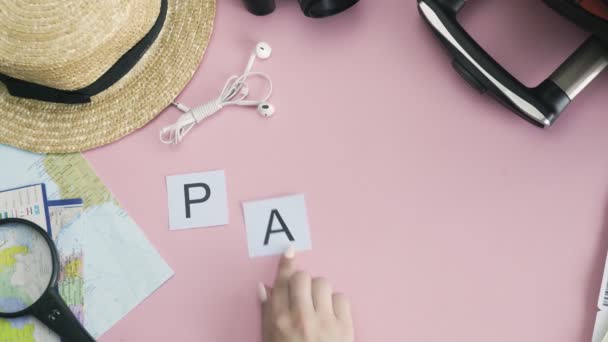 Ovanifrån händer på rosa skrivbord ord PARIS — Stockvideo
