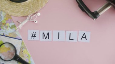 Üst görünüm eller pembe masa kelime MILAN üzerinde yatıyor