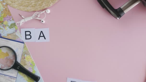 분홍색 책상 단어 BARCELONA 위에 누워 있는 맨 위 사진 손 — 비디오