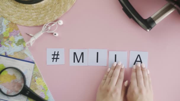 Manos de vista superior que ponen en la palabra de escritorio rosa MILAN — Vídeos de Stock