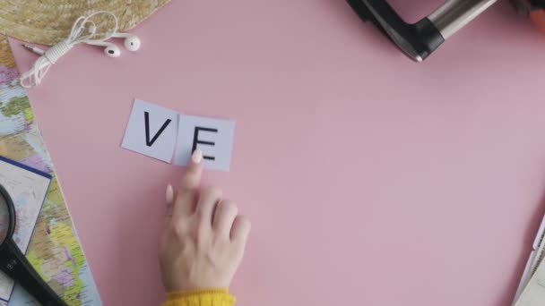 Ovanifrån händer på rosa skrivbord ord VENICE — Stockvideo