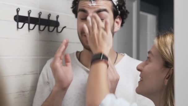 Couple drôle homme et femme appliquant de la crème dans la salle de bain — Video