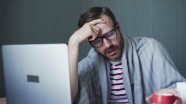 Hastalık sırasında evden çalışan genç bir serbest çalışan. Evde dizüstü bilgisayar ve belgelerle çalışan hasta bir iş adamı.