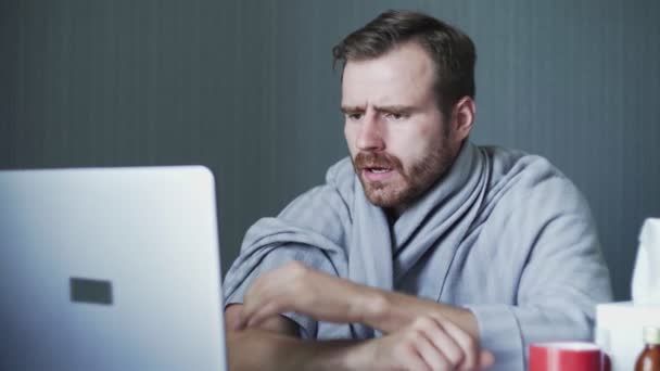 Hombre de negocios enfermo que trabaja con computadora portátil y documentos en casa. El hombre enfermo está sufriendo de dolor de cabeza severo tocándose la cabeza masajeando las sienes en casa . — Vídeos de Stock