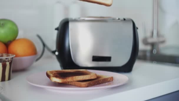 Young man taking slices of bread from toaster to make sandwiches — Stock Video