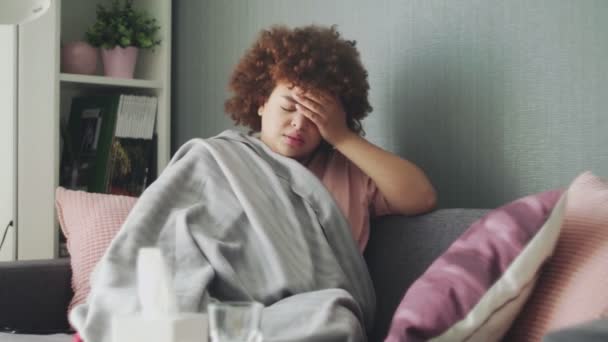 Bedekt met grijze ruit jong Afrikaans Amerikaans meisje ijskoud gevoel thuis, ziek meisje met koorts griep griep temperatuur symptomen — Stockvideo