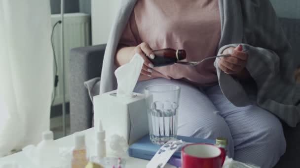 Close up of sick african american girl pouring medication or antipyretic syrup to spoon and drinking it — Stock Video