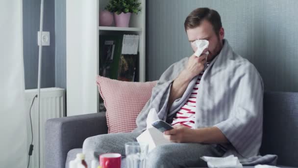 Homem doente com gripe em casa, jovem doente com febre assistindo programa de TV e usando controle remoto . — Vídeo de Stock