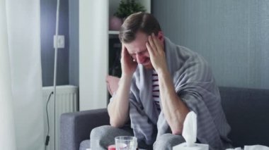 Hasta adam şiddetli baş ağrısından muzdarip. Kafasına dokunuyor. Evdeki tapınaklara masaj yapıyor..