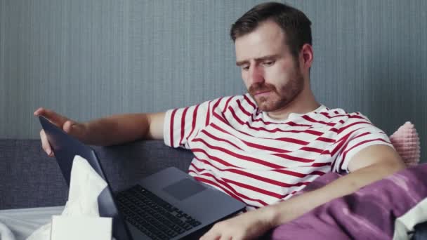 Junger Mann arbeitet im Krankheitsfall von zu Hause aus. Online-Bildung. — Stockvideo