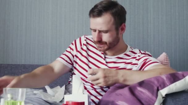 An adult sick man lies on the sofa and taking prescribed medication for illness. — Stock Video