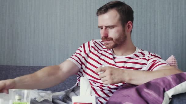 Un hombre adulto enfermo yace en el sofá y toma medicamentos recetados para la enfermedad . — Vídeos de Stock