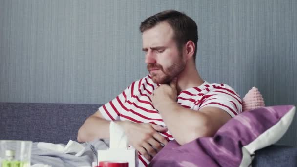 Egy fiatal beteg férfi forró teát iszik otthon. — Stock videók