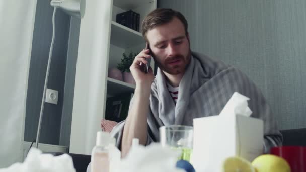 Chory młodzieniec rozmawiający przez telefon w domu. — Wideo stockowe