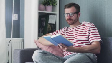 Kafkasyalı genç, gözlüklü, kitap okuyan yakışıklı bir adam.