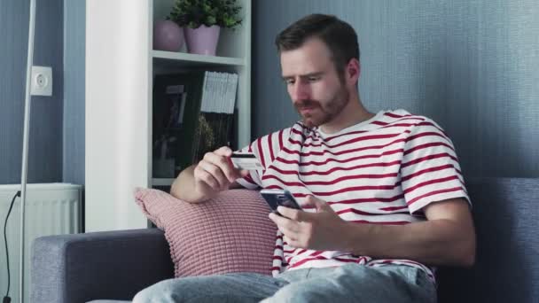 Man met smartphone voor online winkelen met creditcard — Stockvideo