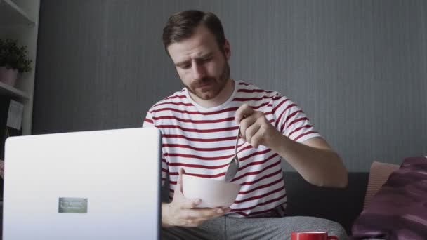 Barbudo hombre terminó el desayuno y cerró un ordenador portátil — Vídeos de Stock