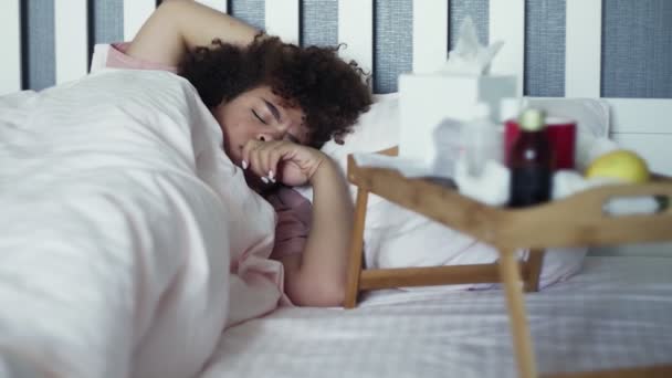 Enfermo joven afroamericano chica está durmiendo durante la enfermedad acostado en la cama — Vídeos de Stock
