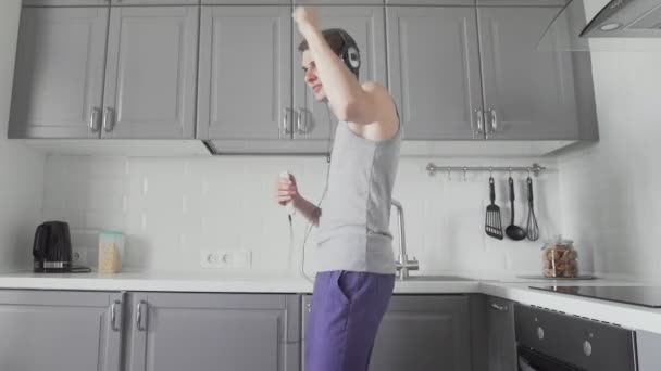 Fešák vtipný muž tančí v kuchyni doma a baví — Stock video