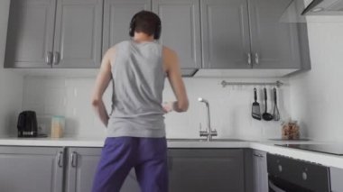 Mutfakta dans eden mutlu genç adam..