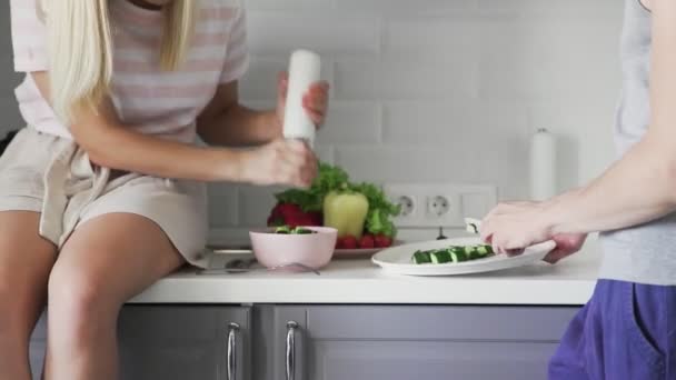 Amar pareja cortar verduras juntos, añadir especias en ensalada para el almuerzo en la cocina — Vídeos de Stock