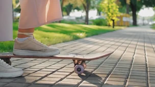 Skateboarder staat met skateboard en duwt het weg — Stockvideo